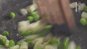 鍋中油7成熱時(shí)，入青豆、筍丁翻炒，然后加糯米飯加鹽均勻翻炒。