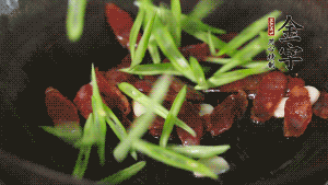 先后下香腸片、四季豆絲均勻翻炒，加適量清水燜煮一下。