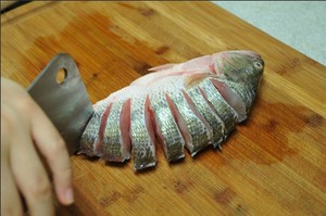 將鱸魚清洗干凈，從脊椎處切斷至腹部，腹部保留1cm左右不要切斷。