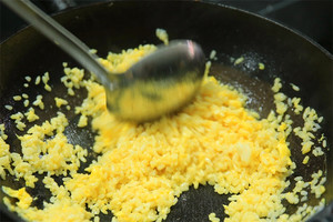 大火加熱炒鍋，再入油，燒到四至五成熱時(shí)倒入雞蛋液，在未凝結(jié)之前，加米飯煸炒，不停翻炒并用鍋鏟將成塊的米飯碾開(kāi)、撥散。