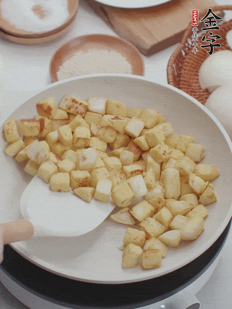起鍋熱油，倒入饅頭丁，小火煎至蛋液凝固定型再翻面，饅頭丁部煎至金黃時盛起待用。