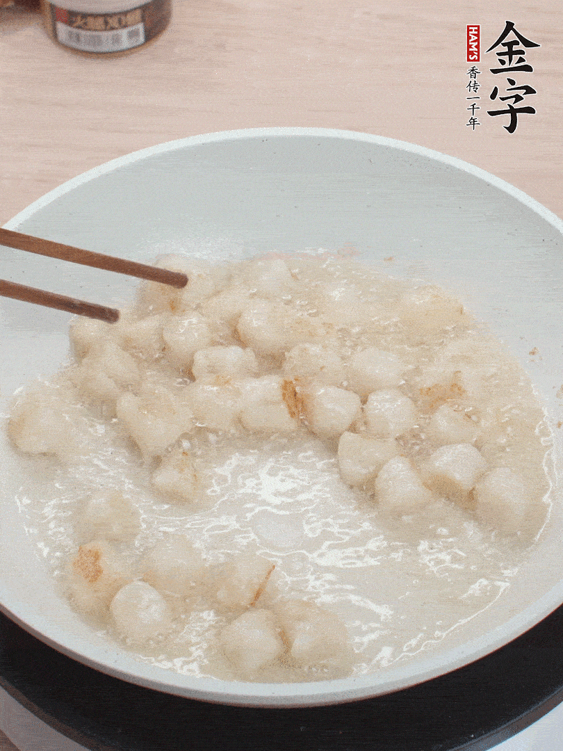 油溫4成熱，鮮貝蘸干淀粉下鍋煎，一面微黃后翻面。