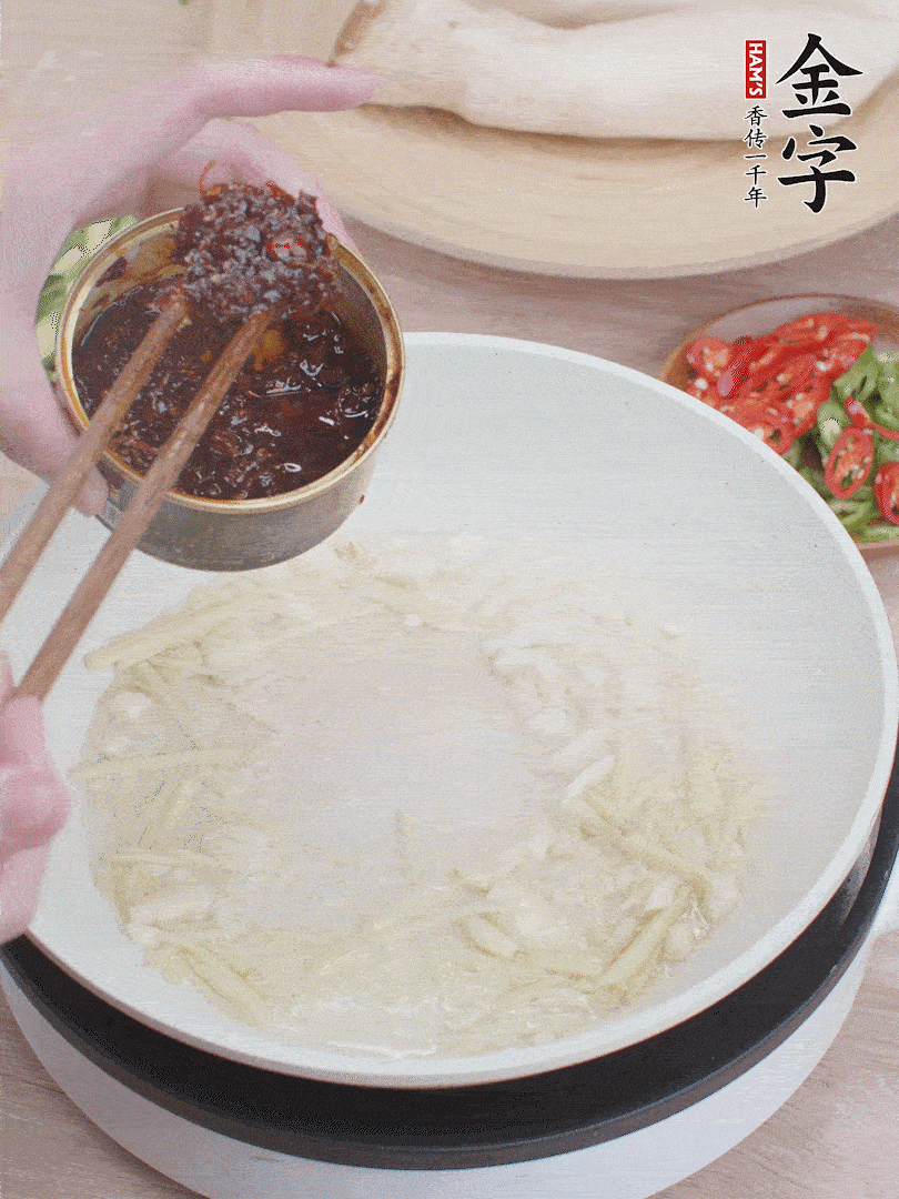 起鍋熱油，姜蒜、金字火腿干貝醬煸香。