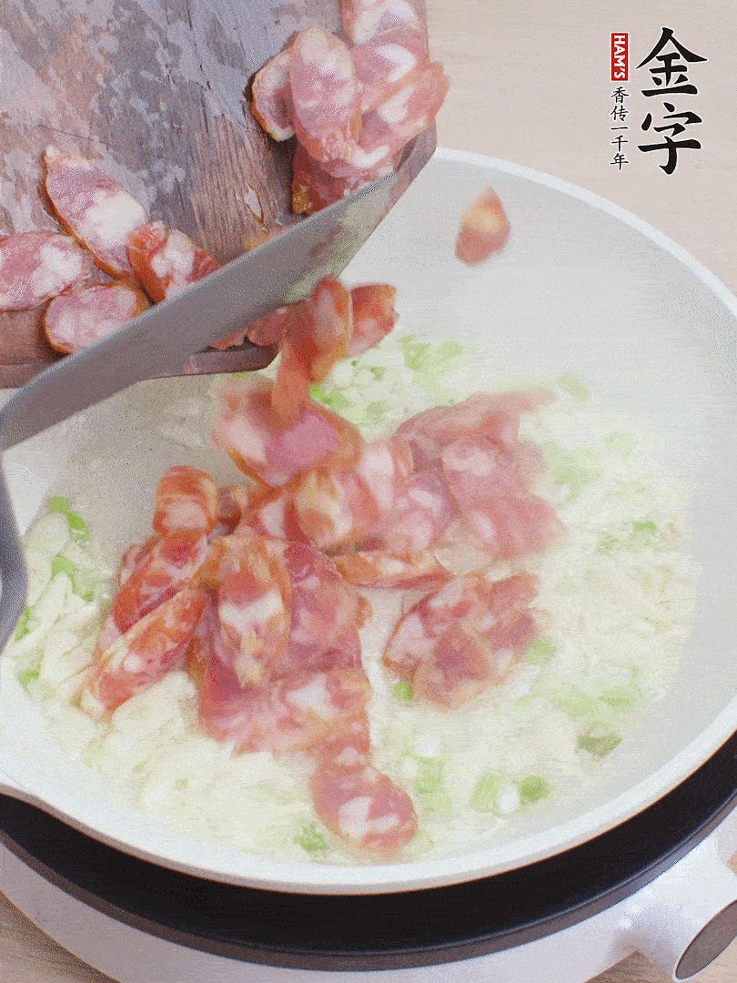 油5成熱，蒜末、蔥白爆香，下香腸炒出香味。