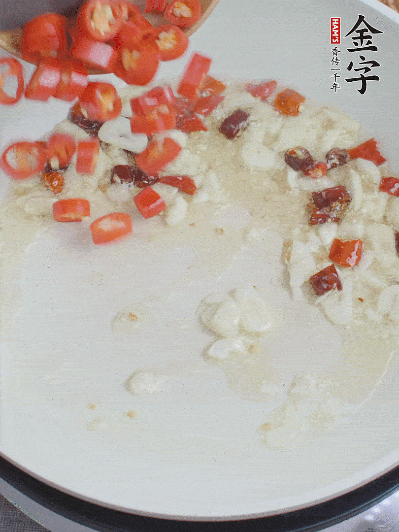 油6成熱，下蒜末、干紅辣椒煸炒，出香味后再放美人椒、香腸。