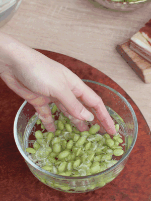 青豆剝殼，搓去外衣。