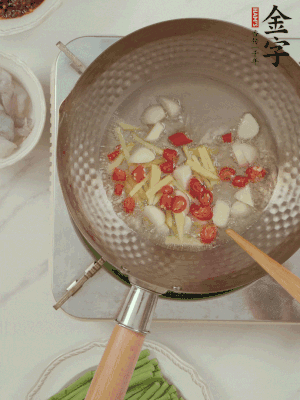 油7成熱時(shí)，下大蒜粒、姜絲、小米辣煸香。