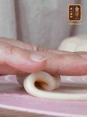 做面劑 油皮按扁，中間包入一個油酥，邊緣收緊捏死。包好的面劑按扁，用搟面杖搟壓成橢圓形。從底部向上卷成筒狀，用保鮮膜蓋好松弛15分鐘，再把筒狀縱向搟壓成長條狀。再卷一次，松弛20分鐘