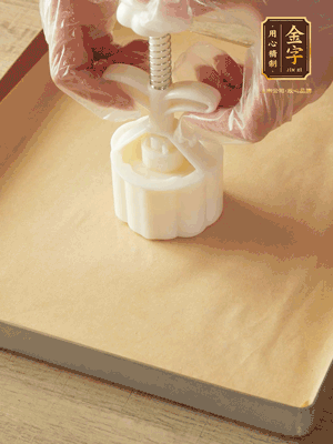 取一個(gè)面團(tuán)，捏扁，中間厚，四周薄。虎口往上推，直到收口，把餅胚放入模具里，壓2-3下