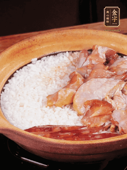 煮到椰子水微微收干轉(zhuǎn)小火，快速均勻鋪上雞肉、金字香腸