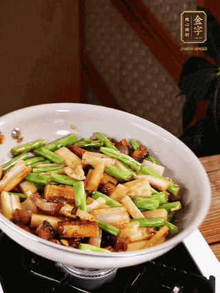 油熱下蒜末、干辣椒、醬肉煸炒出香味，依次下藕條、豆角翻炒均勻